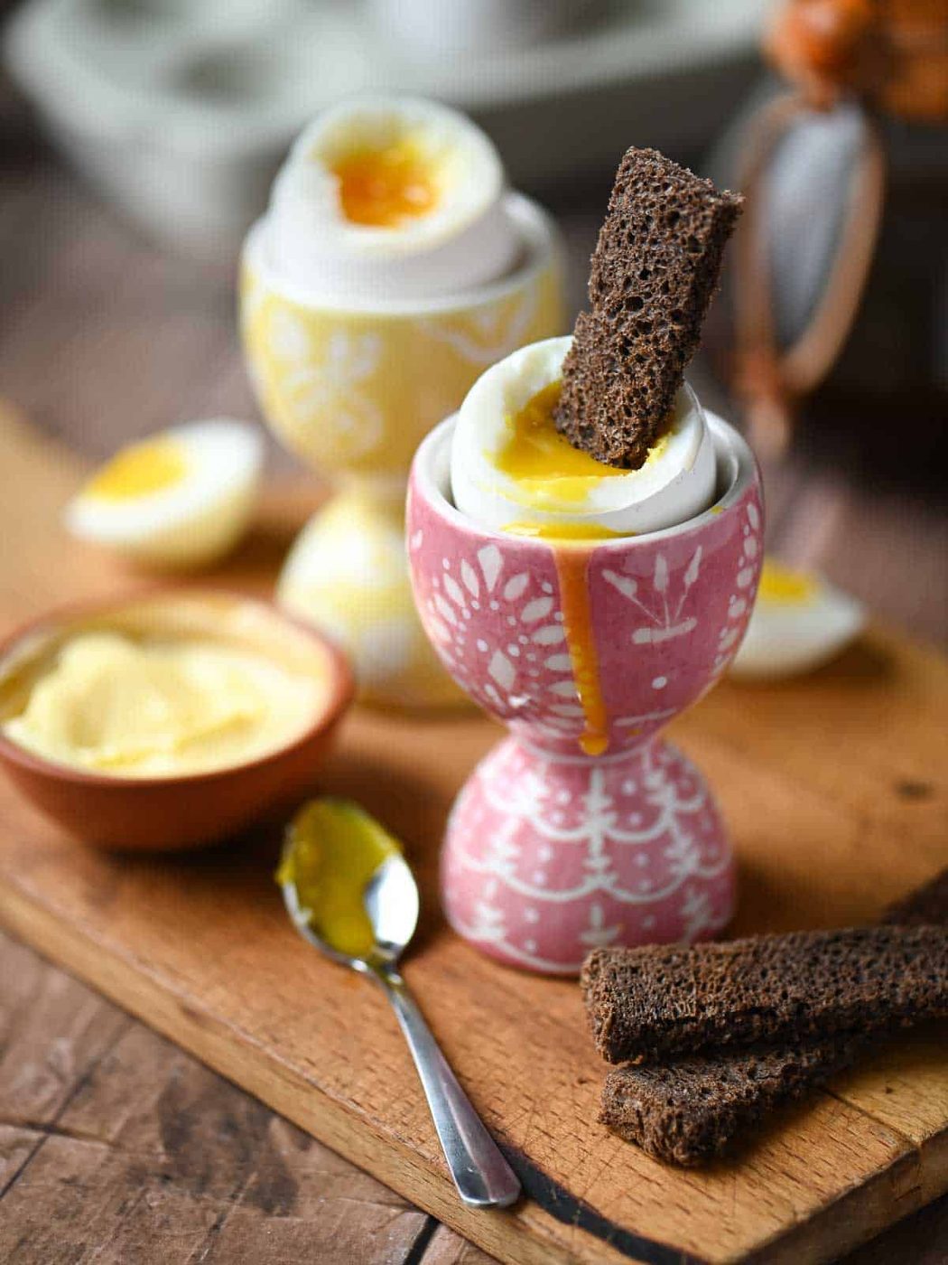 A slice of toast in a soft boiled egg inside a pink egg holder.
