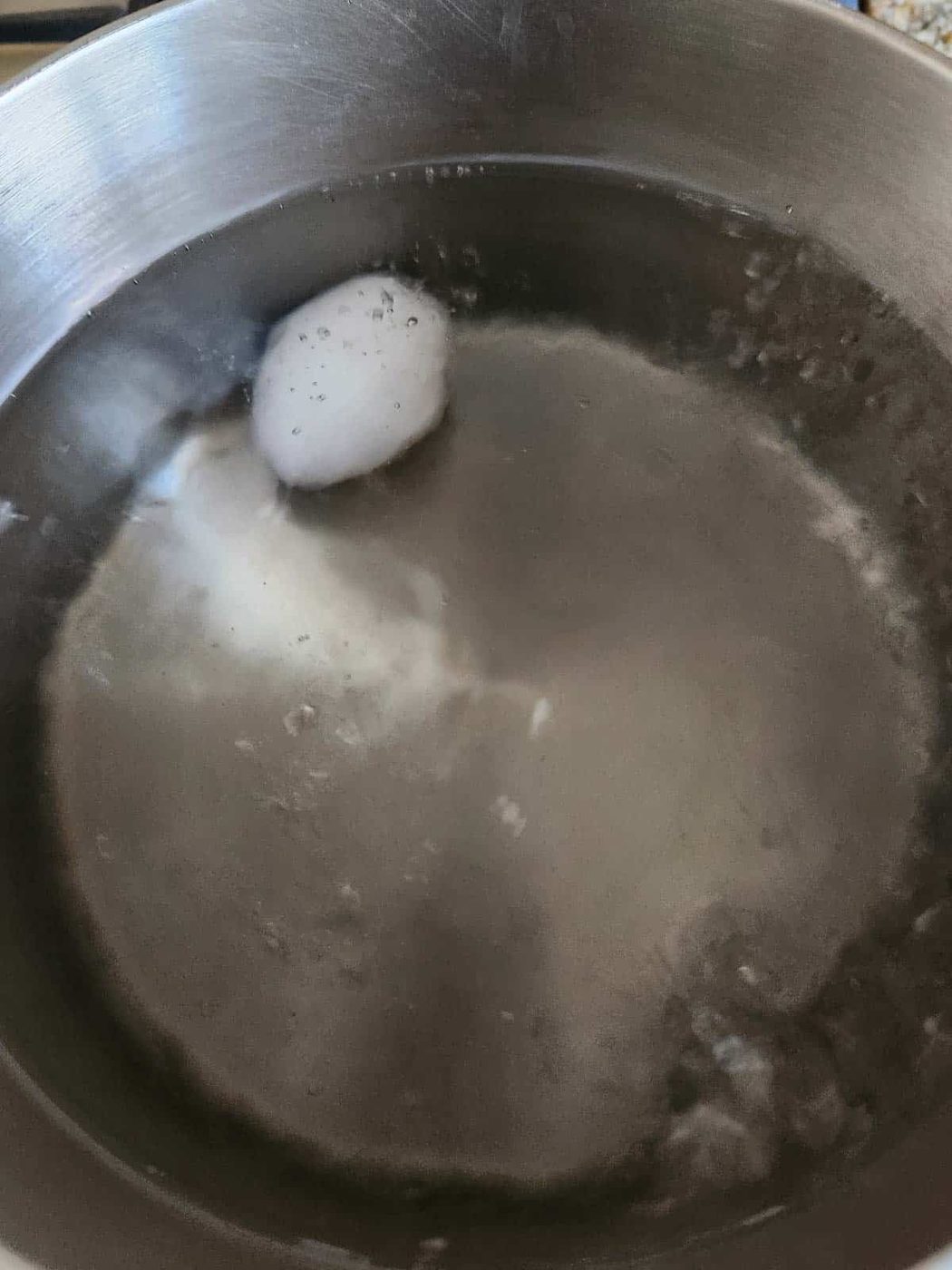 An egg in pot of boiling water.