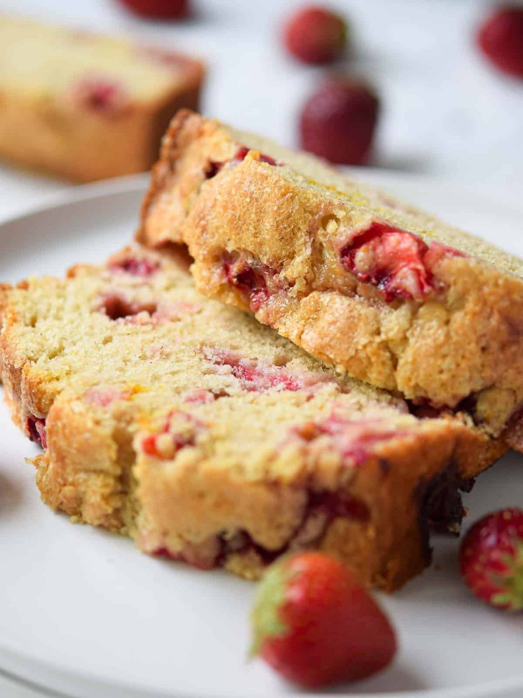 Close-up of sliced strawberry bread on a white plate.