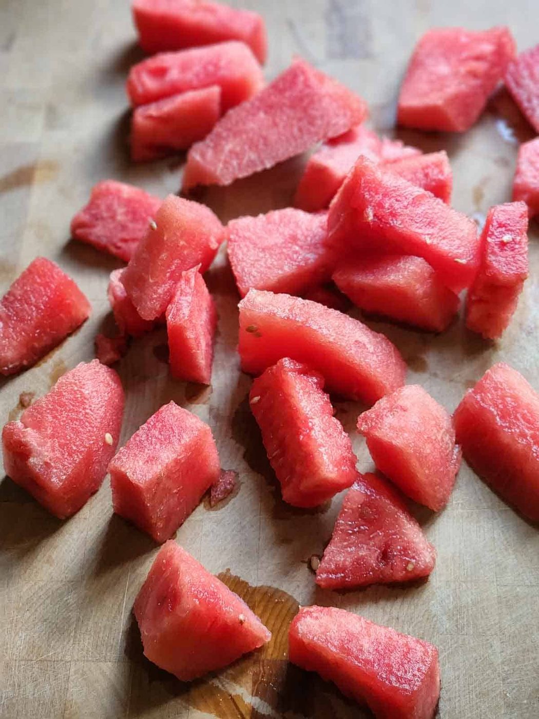 Chopped watermelon cubes on a cutting board.