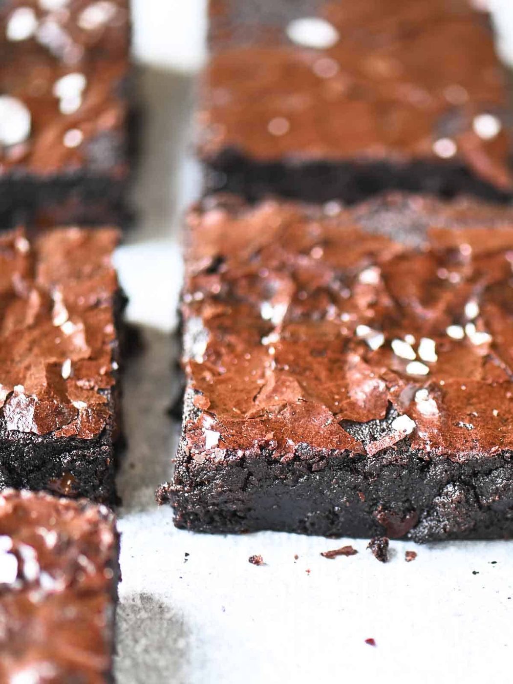 An angled view of Valrhona chocolate brownies on parchment paper.