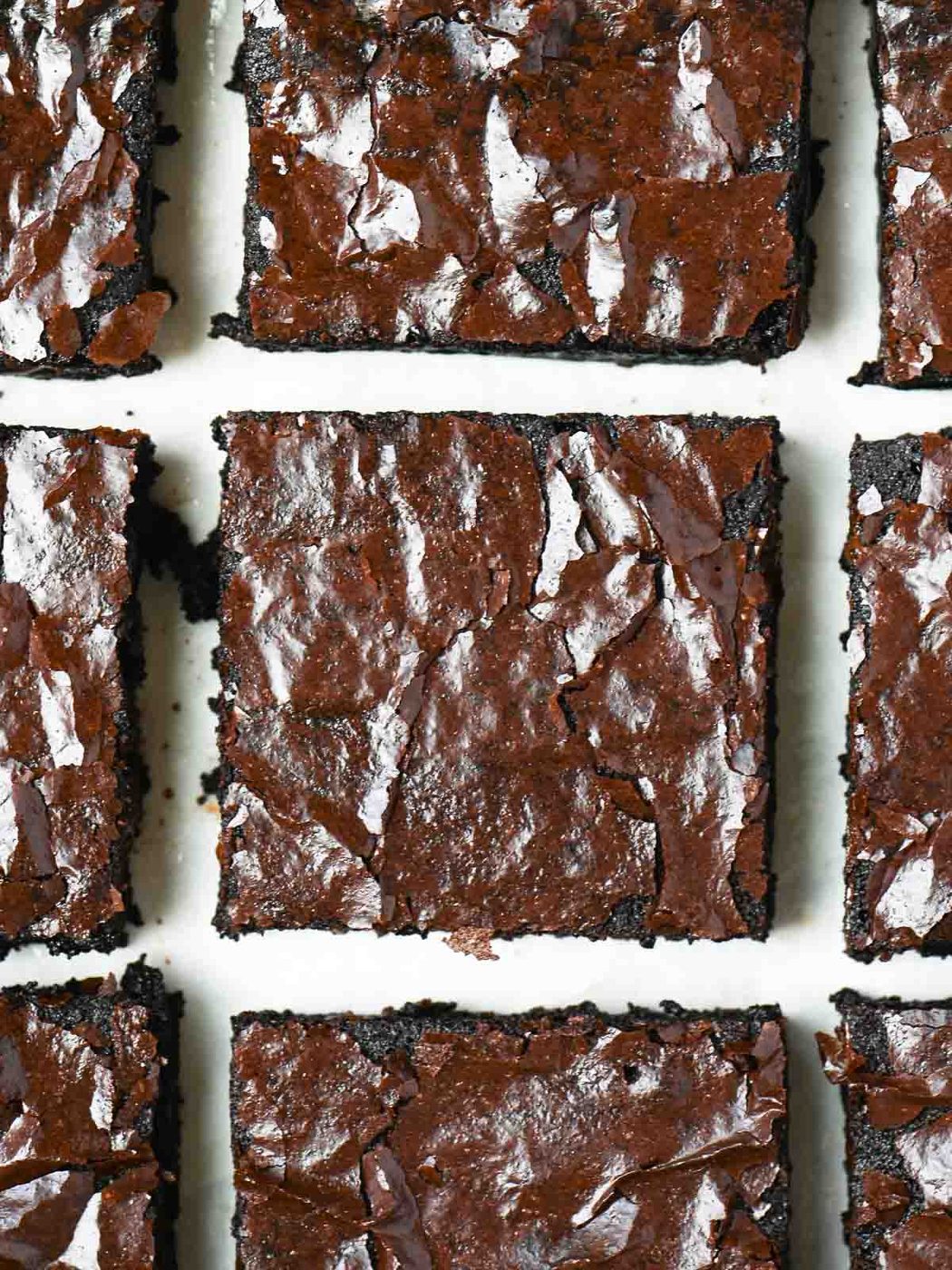 A close up of brownies on a white surface.