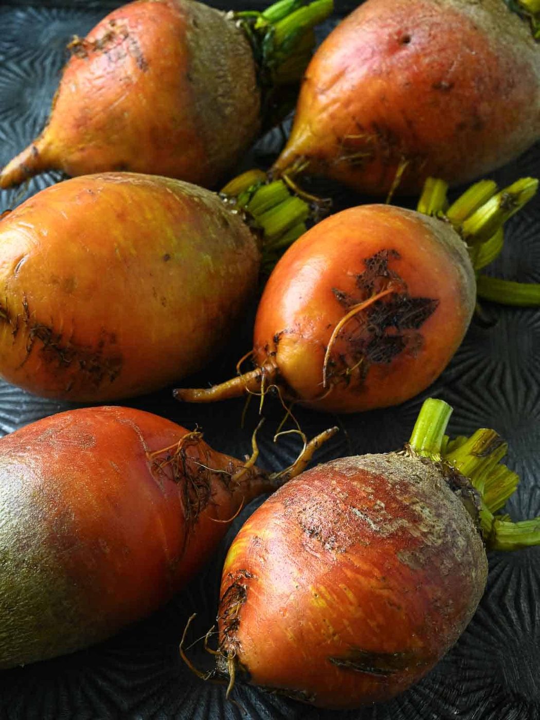 Washed yellow beets on a metal tray.