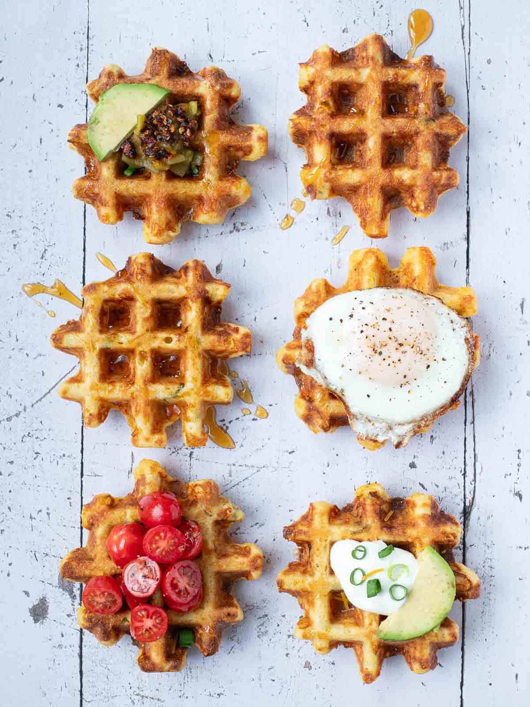 Overhead of 6 waffles with various topping on them.