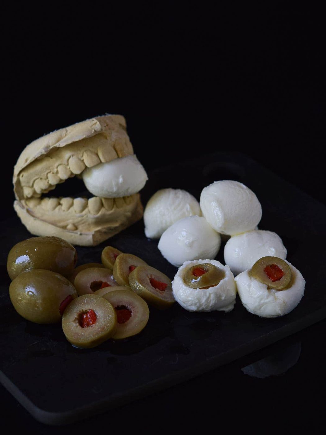Mozzarella balls and olives are cut out with the olive inserted into the mozzarella.