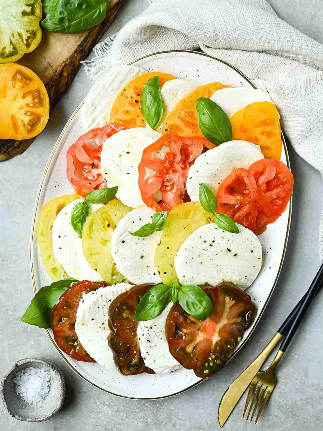 Overhead of Italian Caprese salad on a white platter.