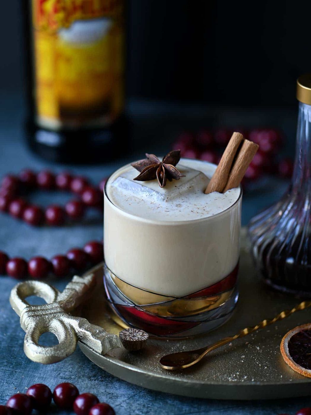 White Russian in a clear glass on a gold tray.
