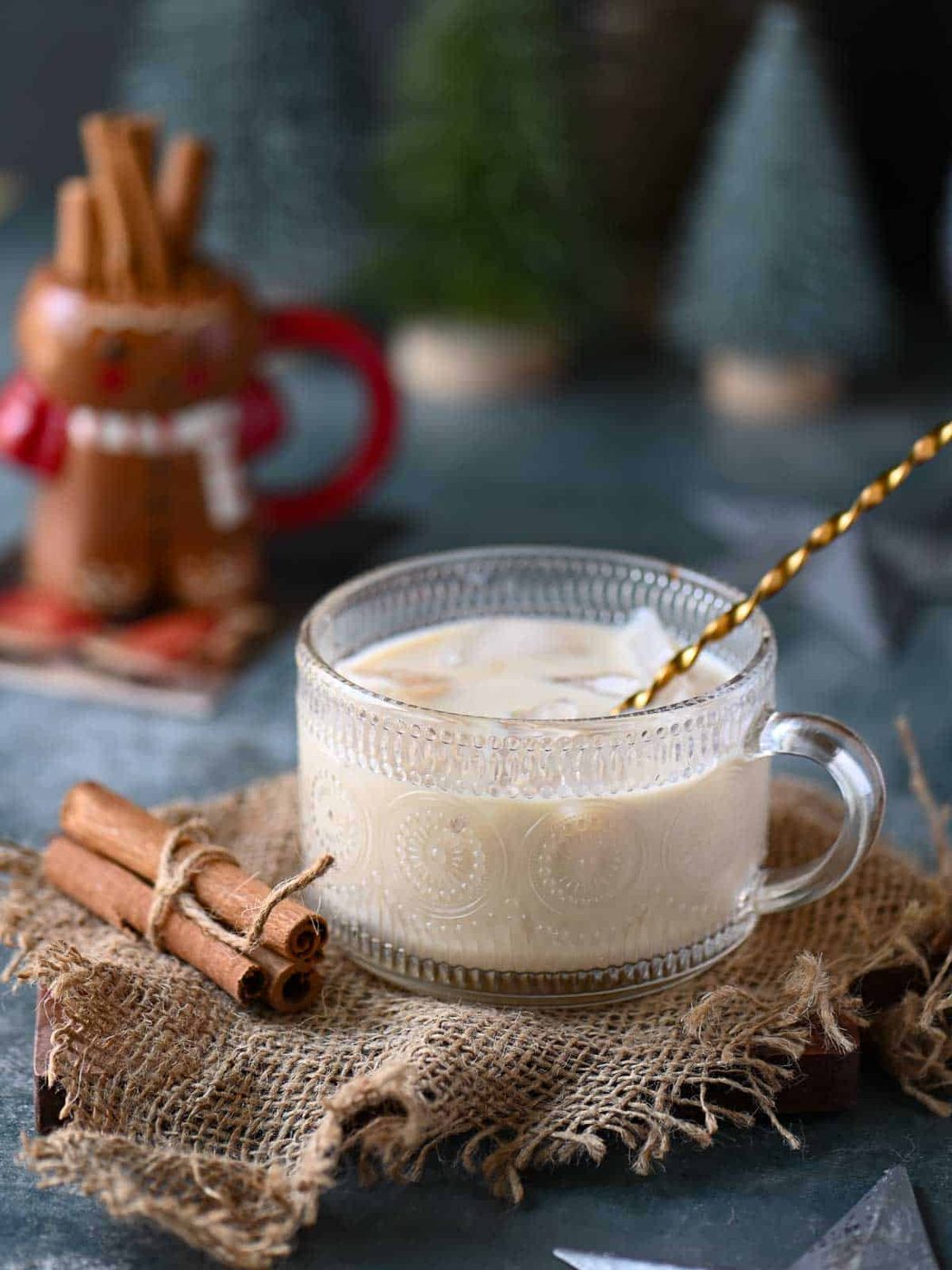 An eggnog white Russian in a clear class with a stirrer in it.