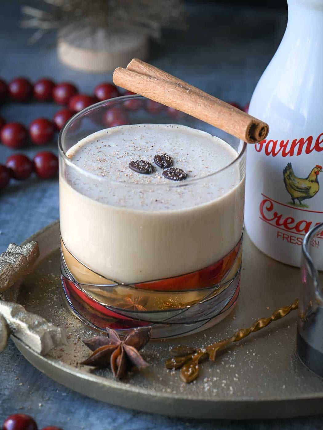 Close up of an eggnog White Russian drink in a clear glass garnished with coffee beans.