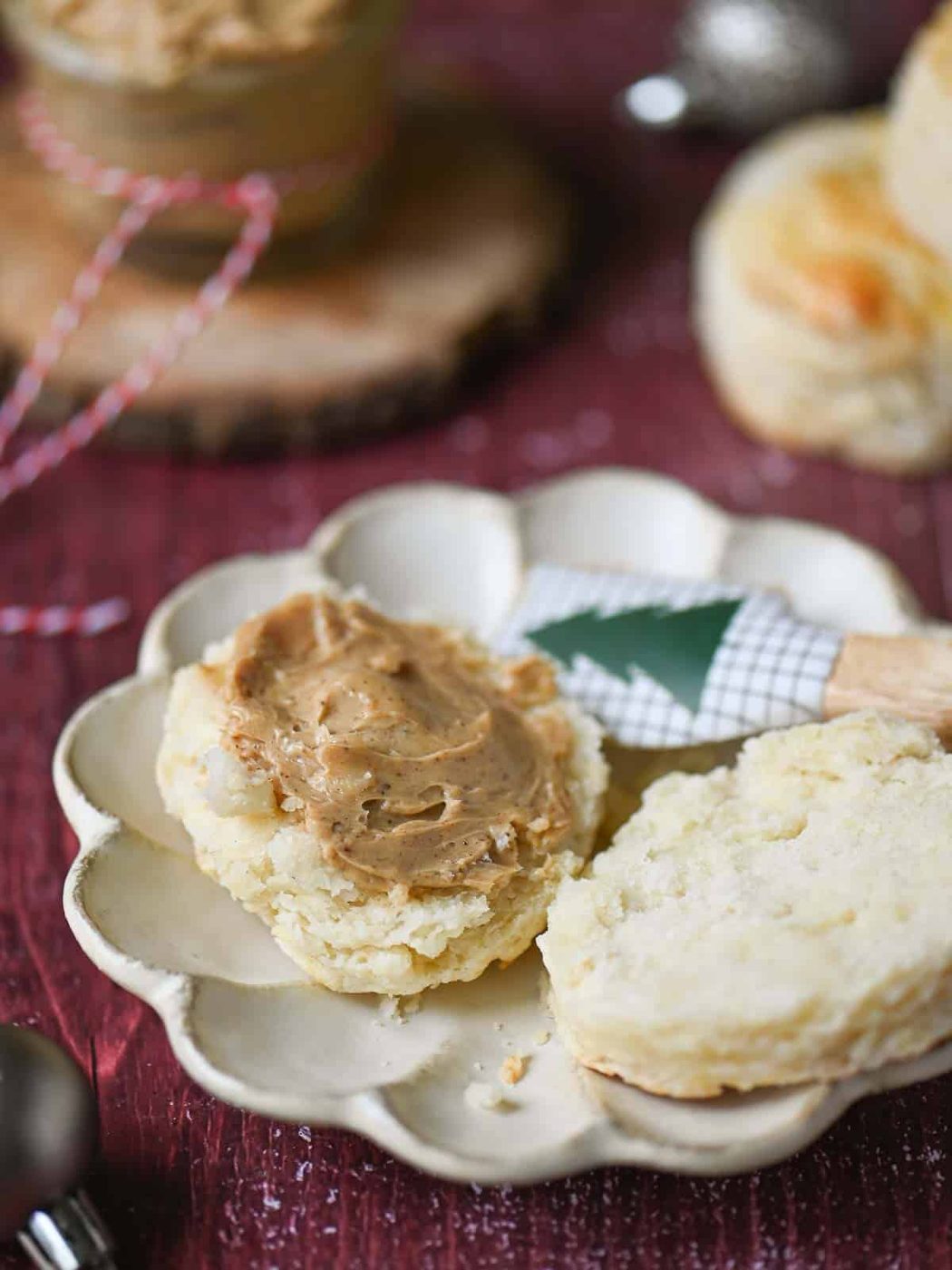Gingerbread butter spread on an open biscuit on a red table.