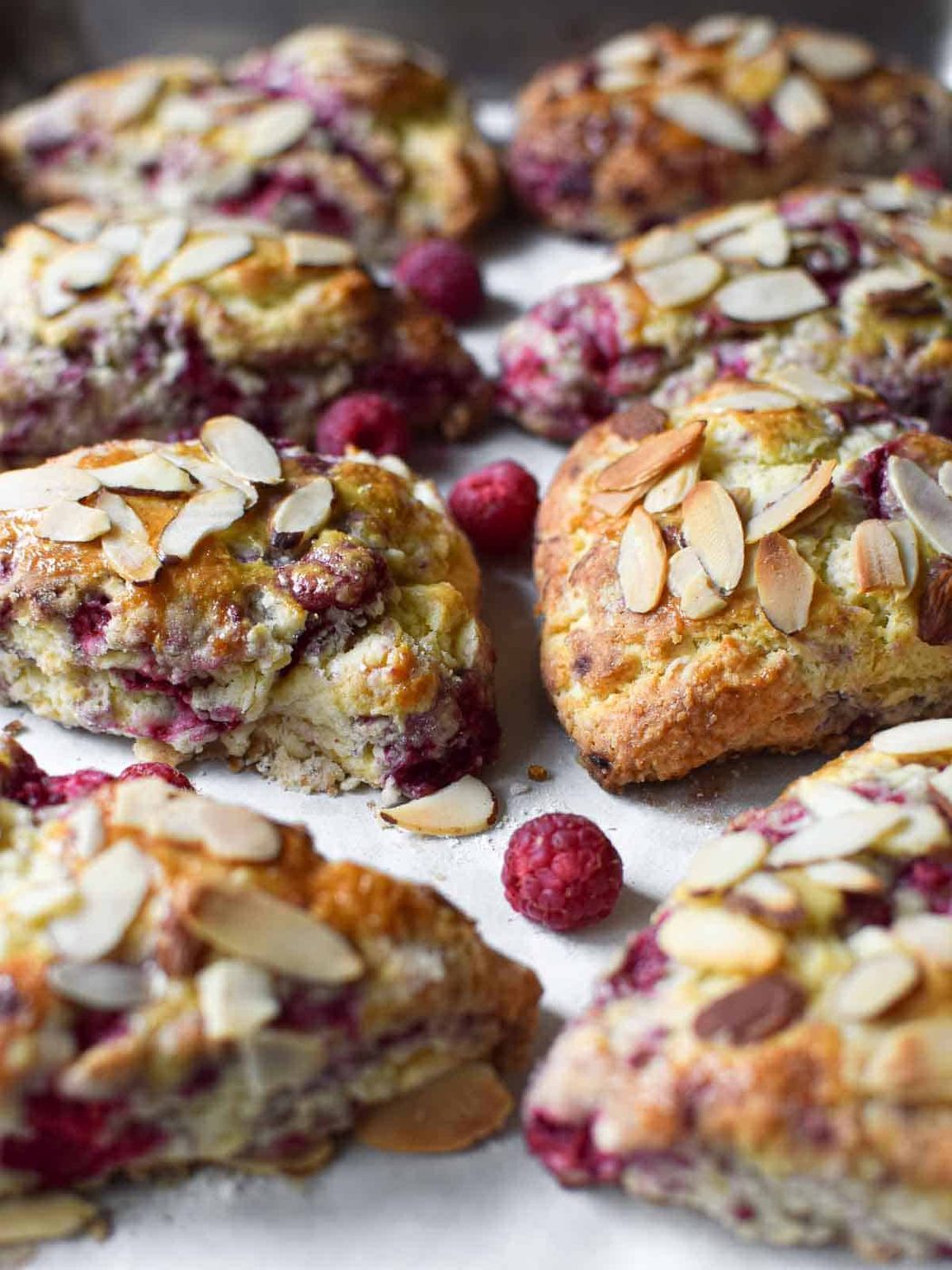 Raspberry almond scones on a baking pan.