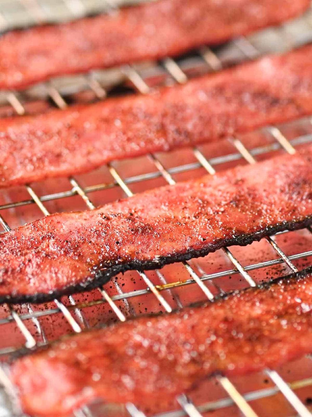 Close-up of cooked turkey bacon on a wire rack.