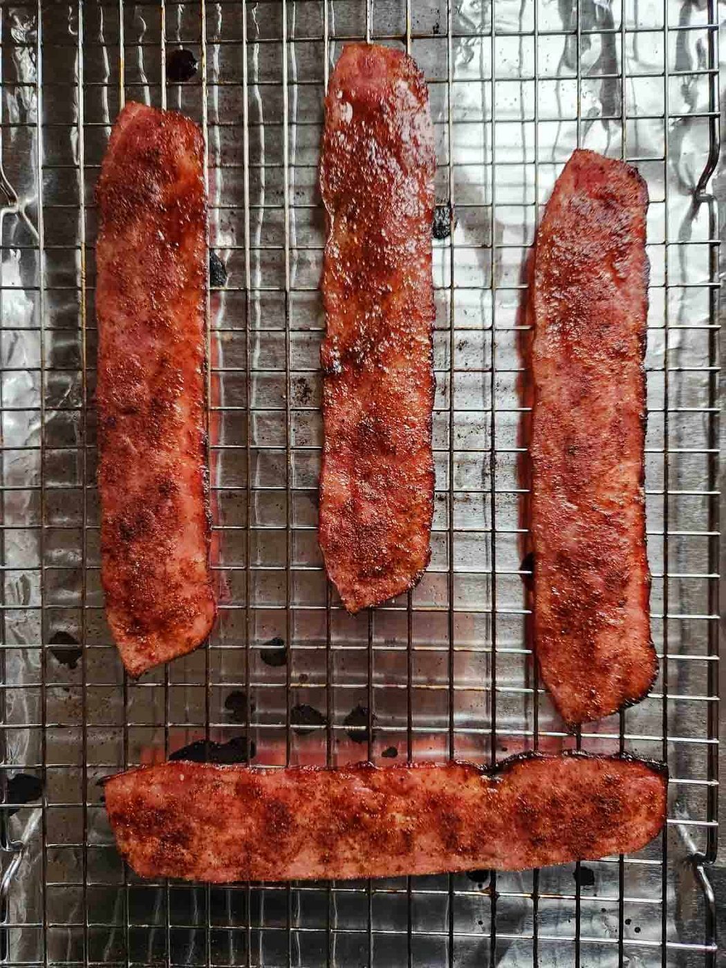 Cooked turkey bacon on a baking tray showing crisp edges.
