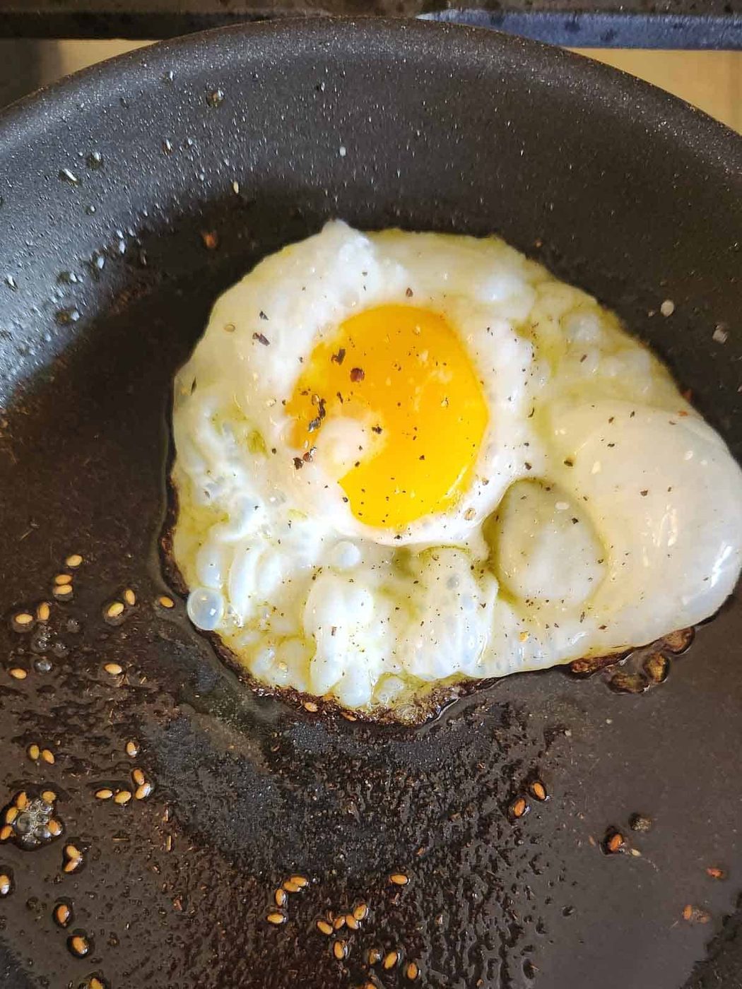 Fried egg in a black skillet.
