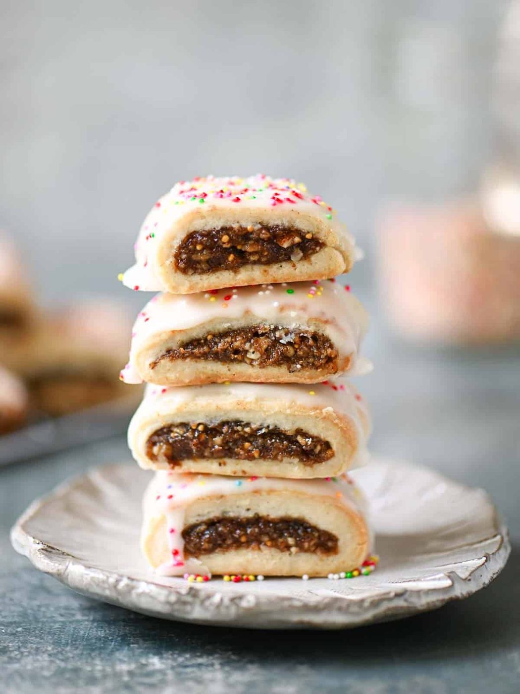 A stack of four cuccidati on a grey plate.
