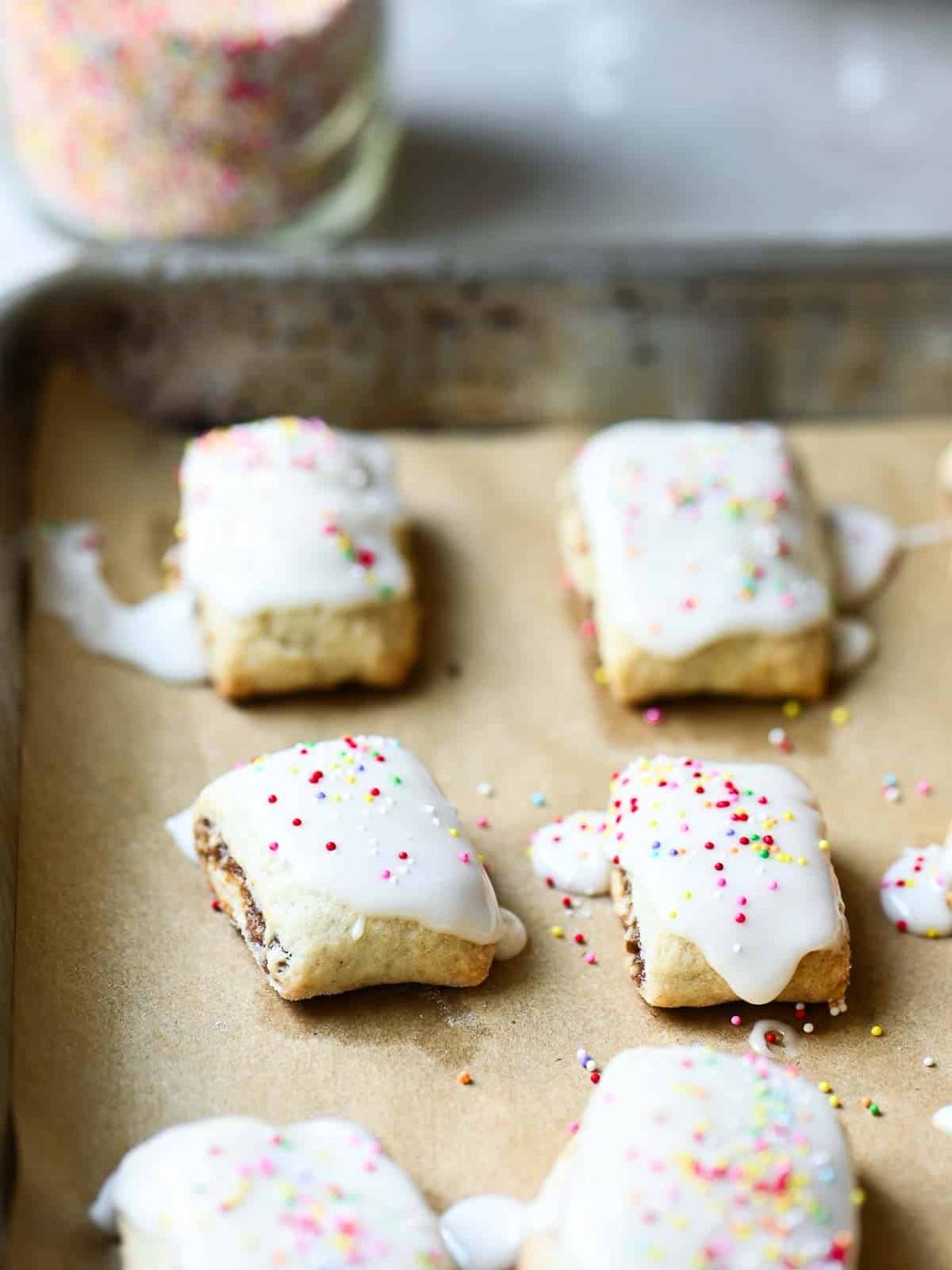Italian fig cookies on a parchment with colorful sprinkles on top.