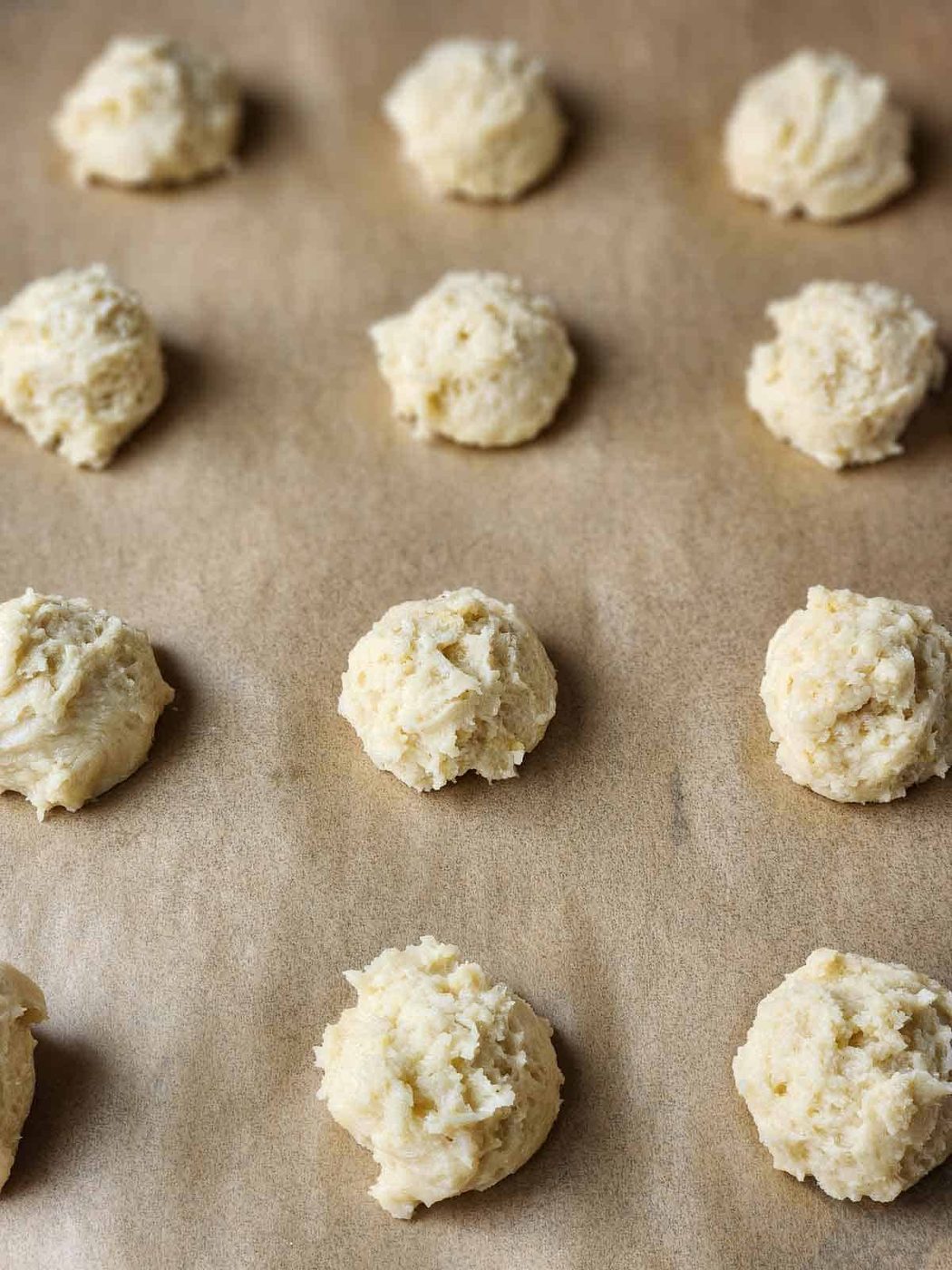 Mounds of cookie batter on parchment paper.