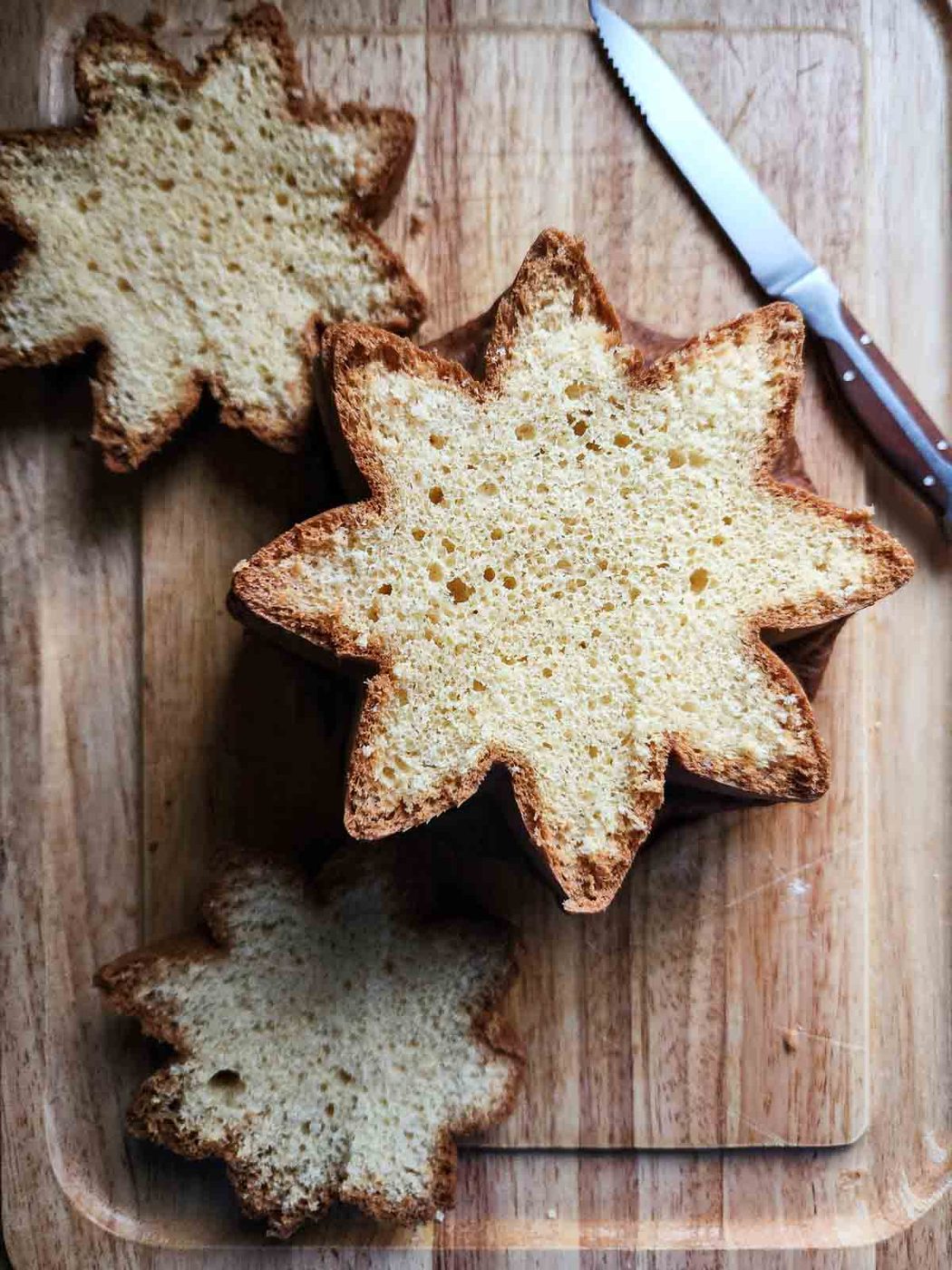 Overhead of sliced pandoro showing its star shape on a cutting board.