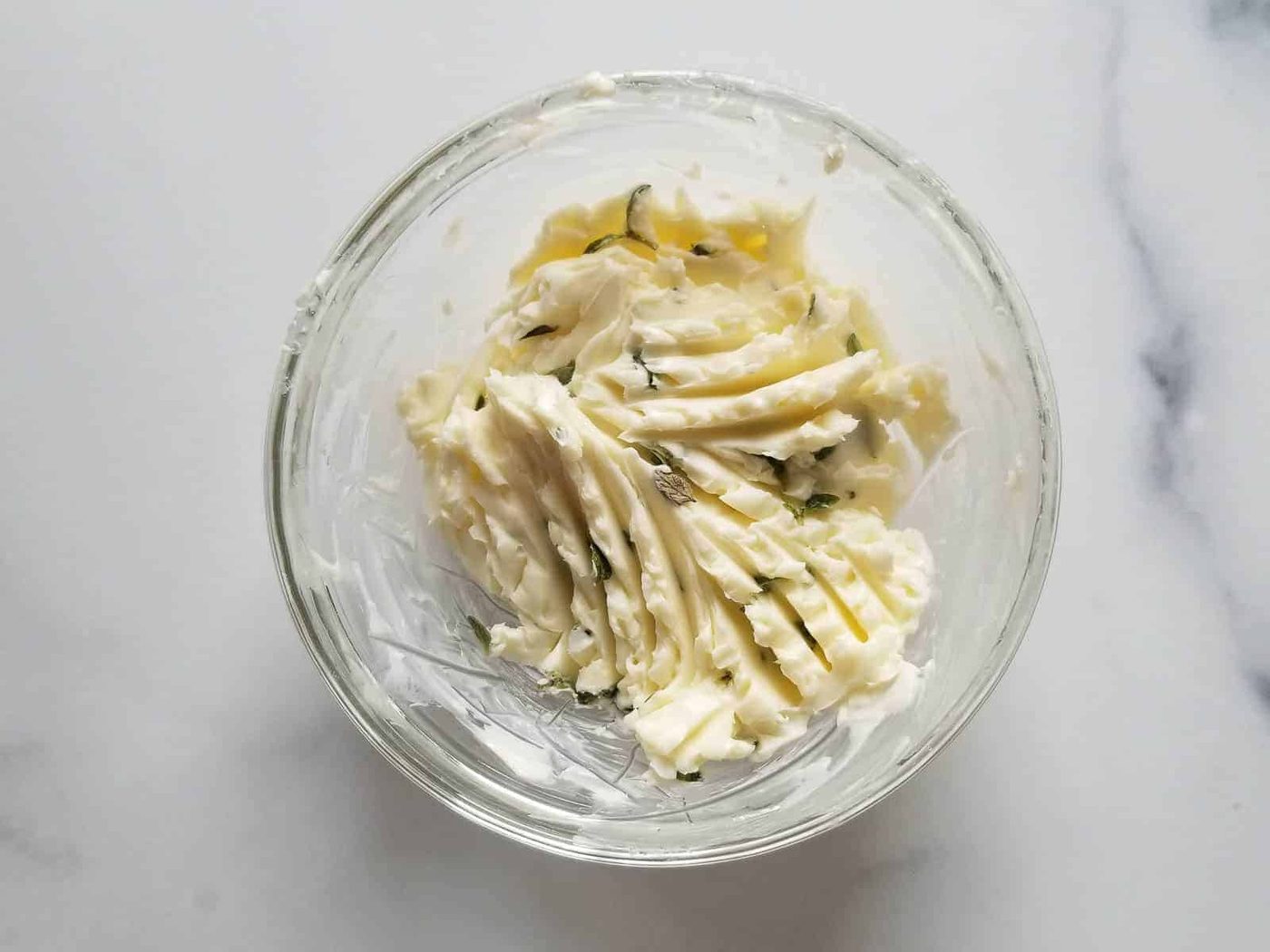 Butter mixed with thyme in a small bowl.