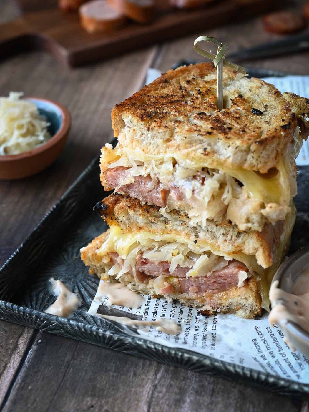 Kielbasa sandwiches stacked on top of each other with condiments on the side.