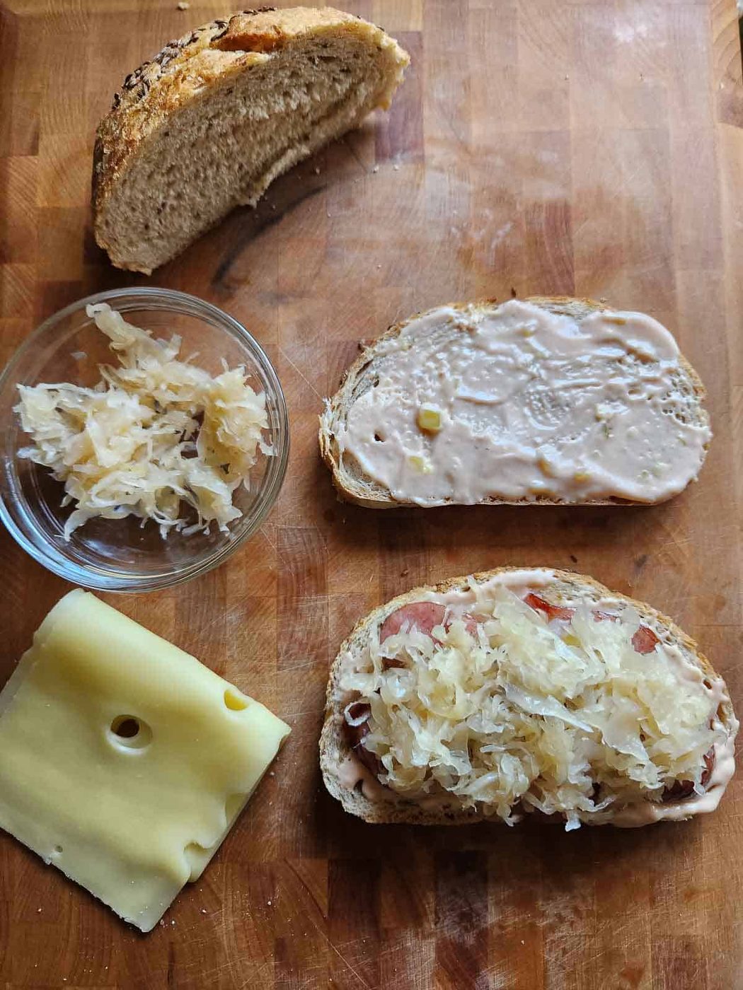 Bread, sauerkraut and cheese on a cutting board.