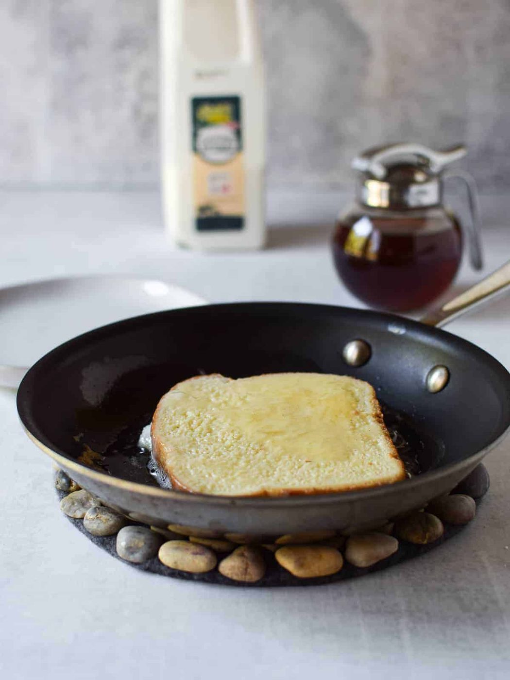 Soaked bread in a frying pan cooking for French toast.