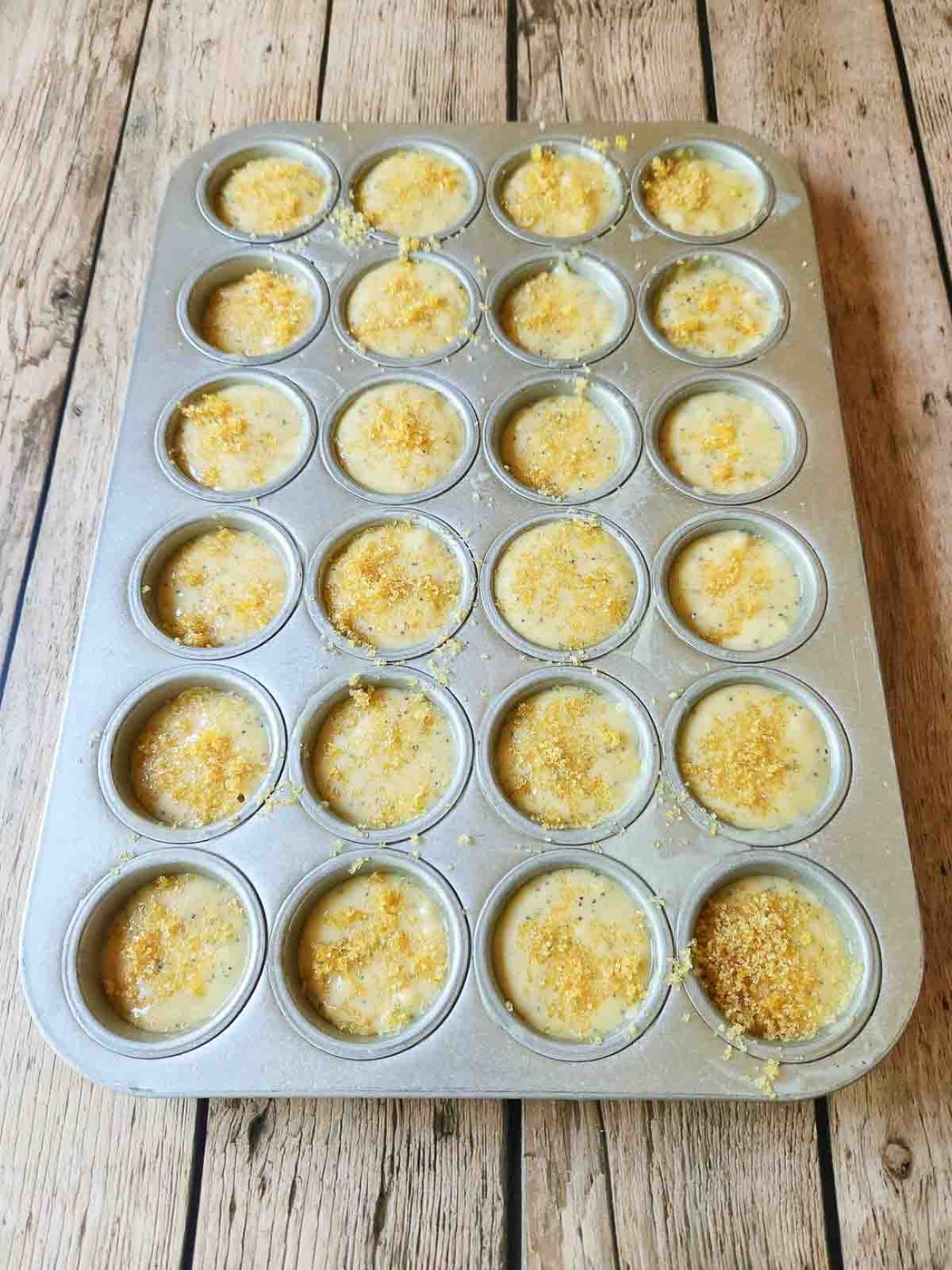Muffin batter in a 24 cup muffin tin.