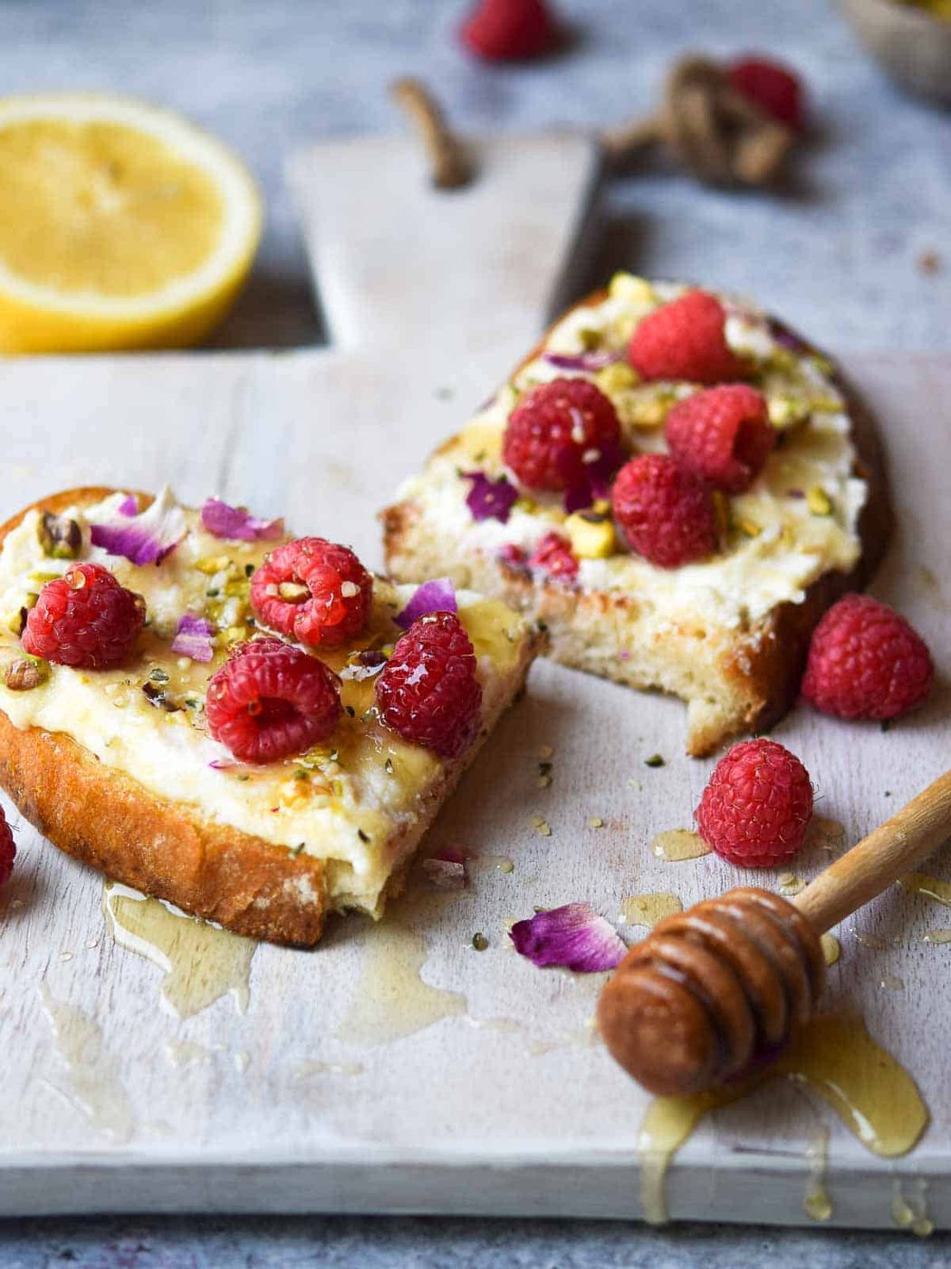 Raspberry toast cut in half with honey dripping down a cutting board.