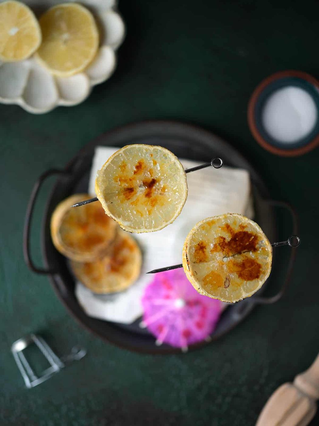 Overhead view of bruleed lemon slices on top of glasses.