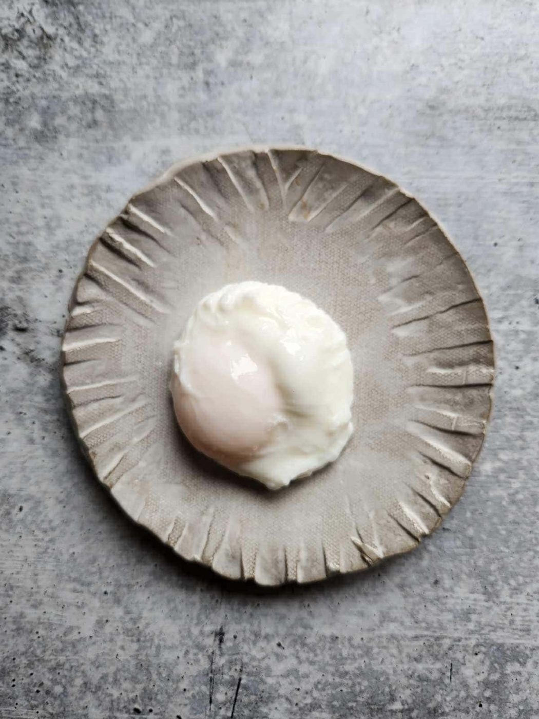 Poached egg on a grey plate.