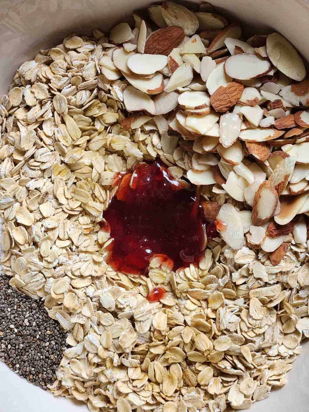 Ingredients in a bowl for mixed berry granola.