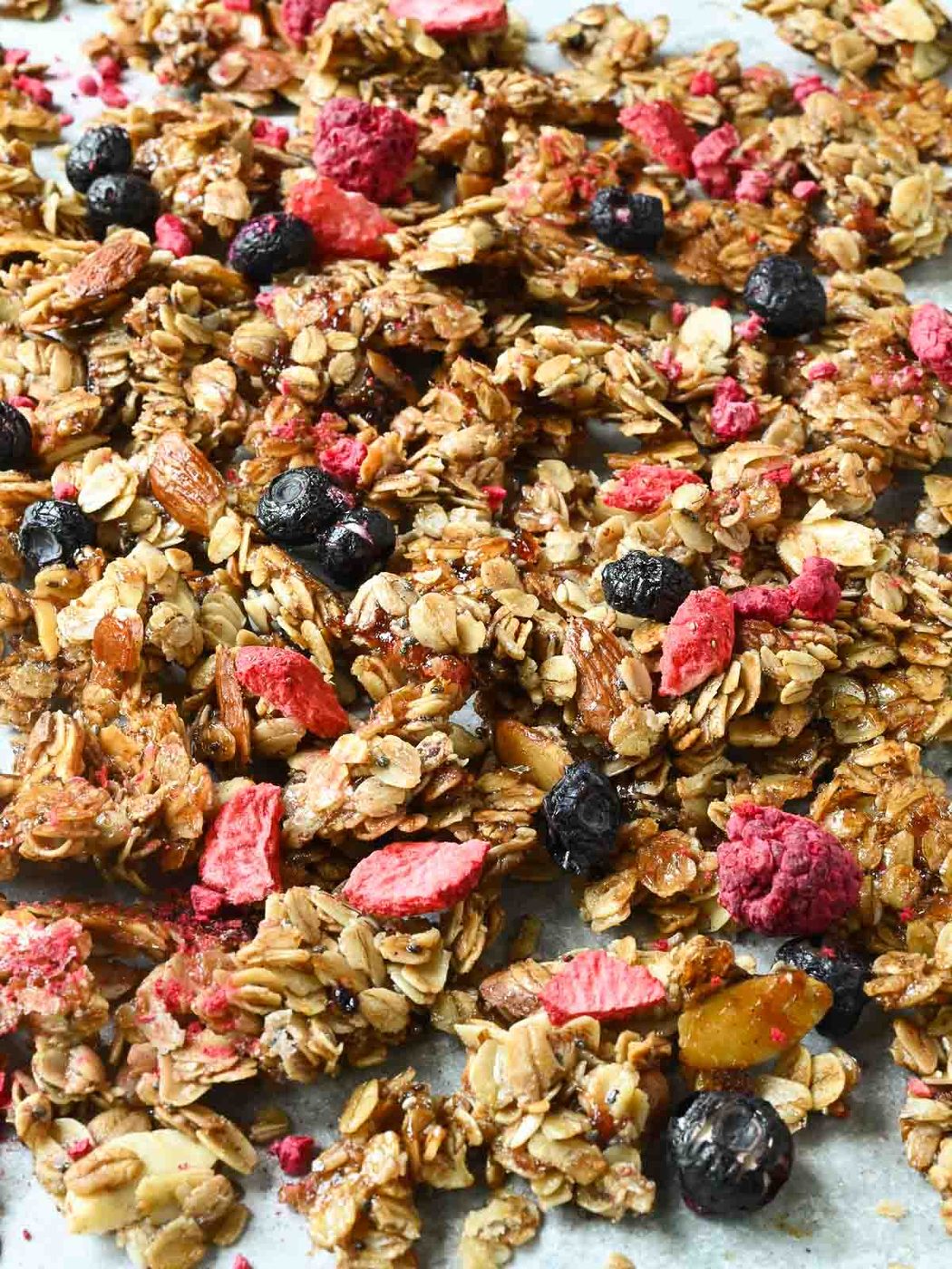 Cooked mixed berry granola on a baking sheet.