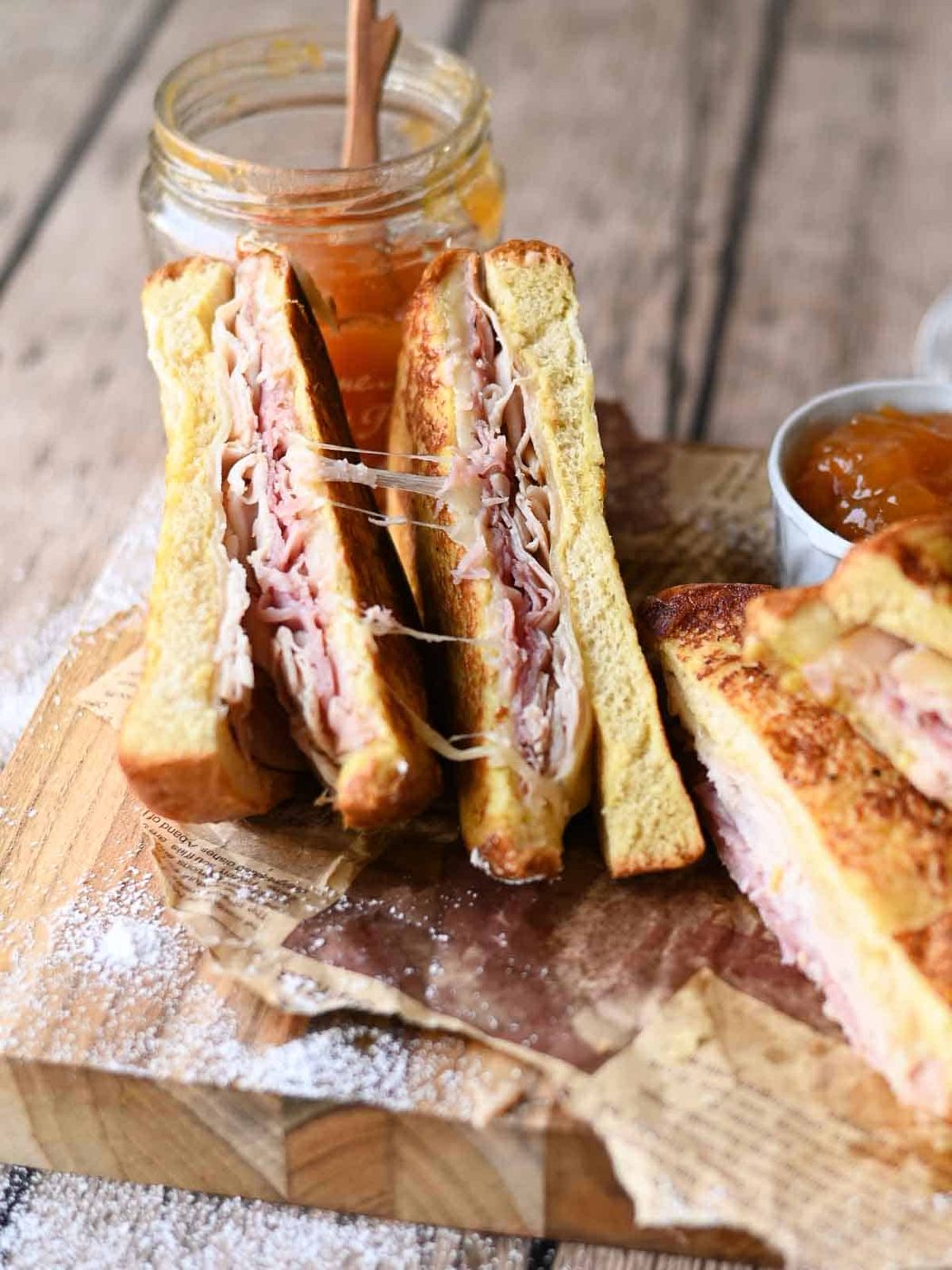 Monte Cristo sandwich sliced showing the inside on a wooden board.