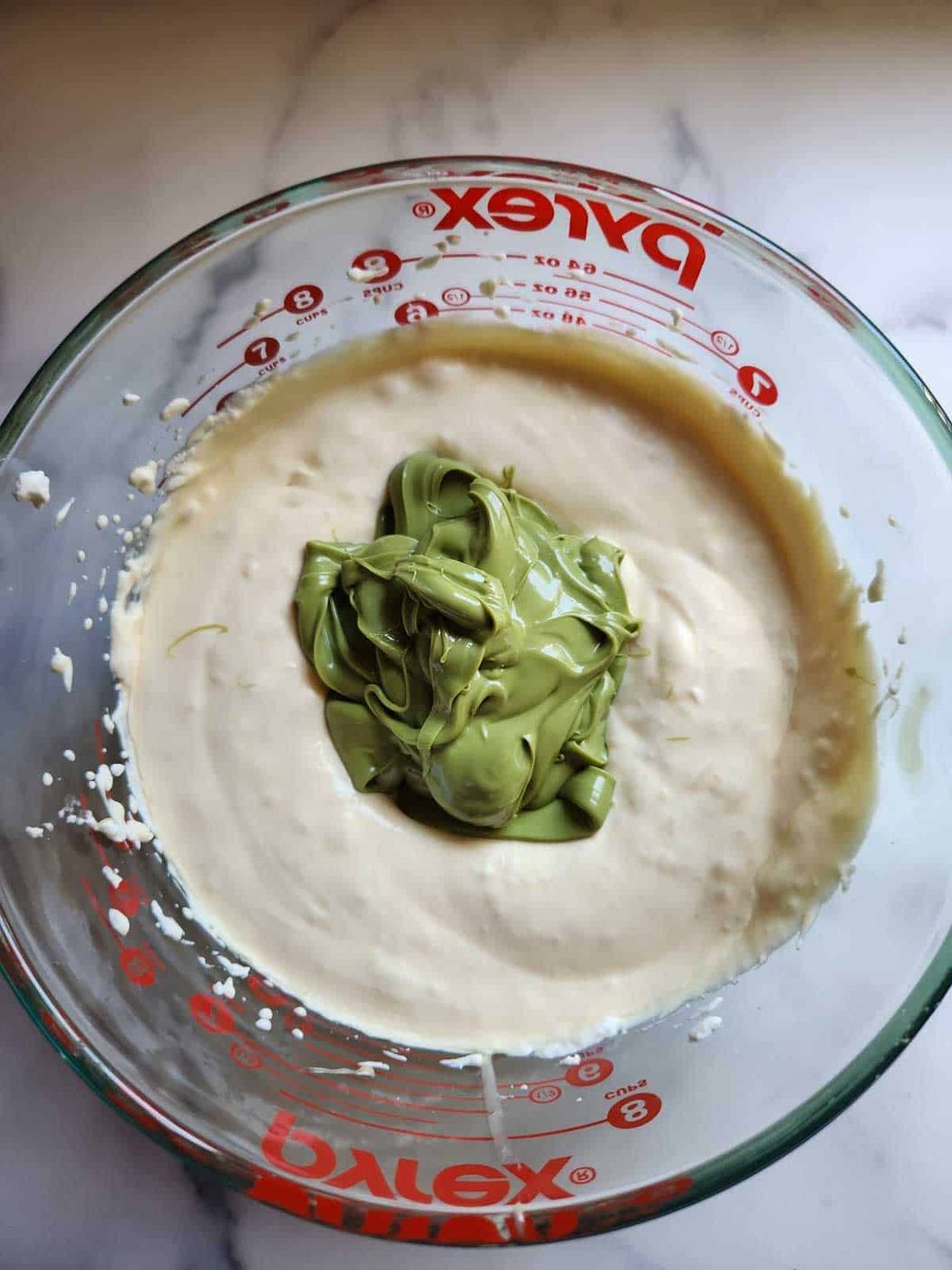 Pistachio paste and whipped cream in a bowl.