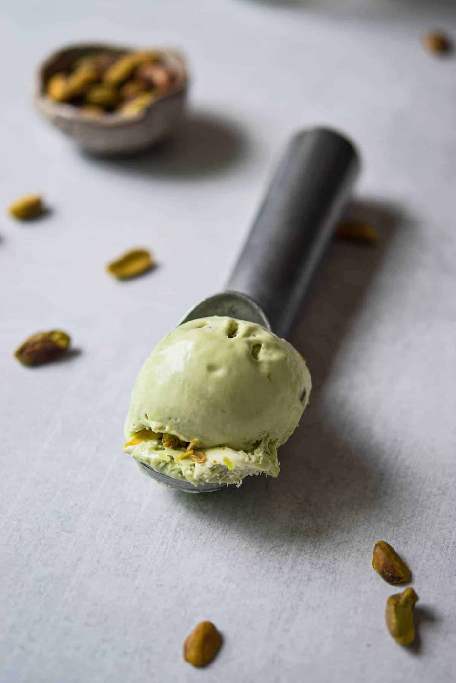 Scoop of pistachio ice cream on a metal ice cream scoop.