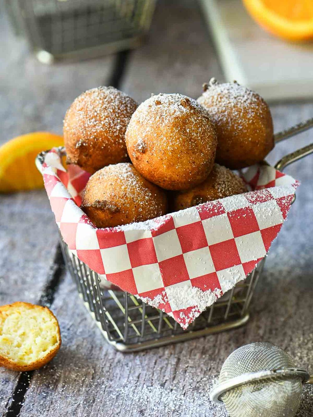 Ricotta doughnuts in a fry basket with a red checkered liner.