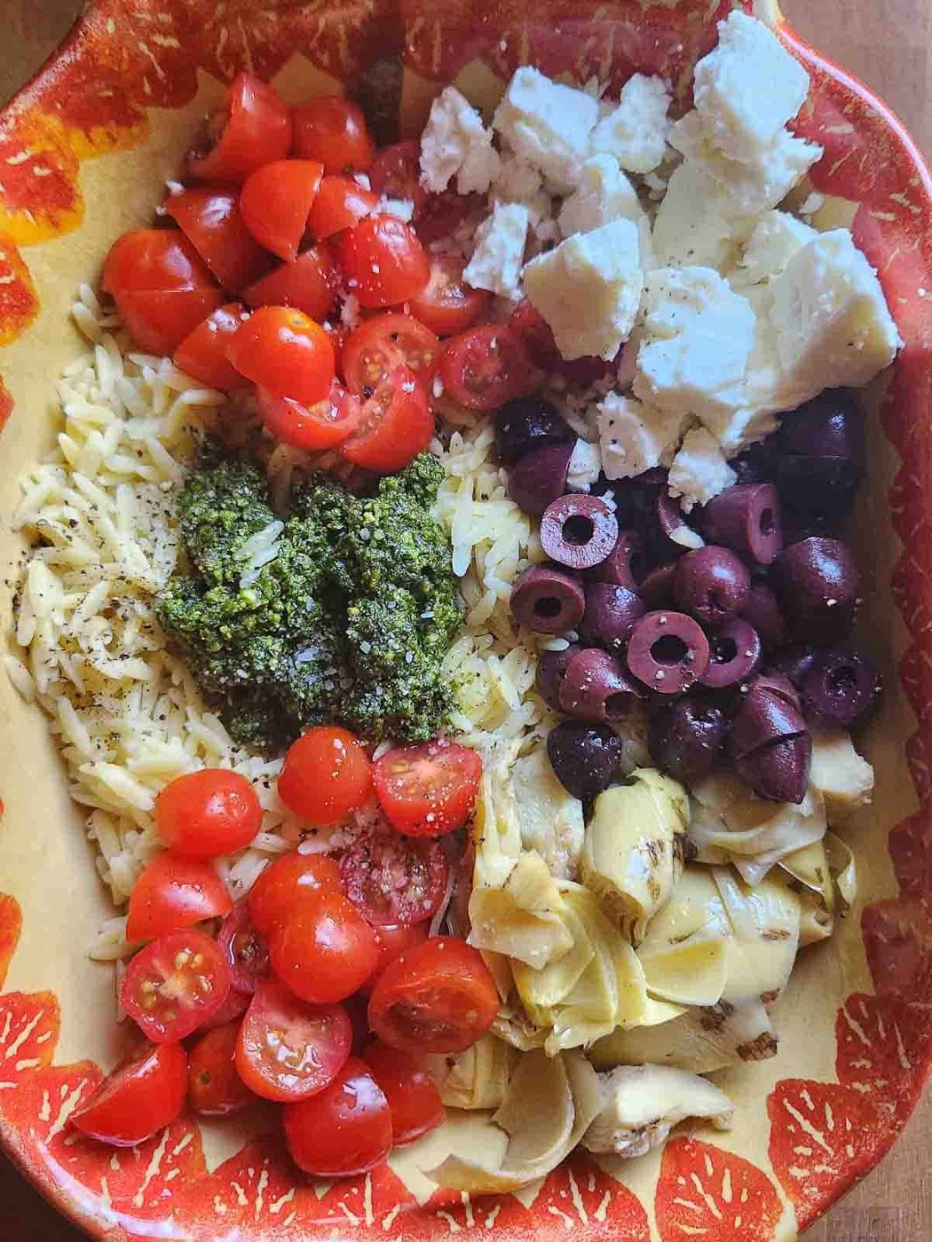 Ingredients in a bowl for orzo pasta salad.