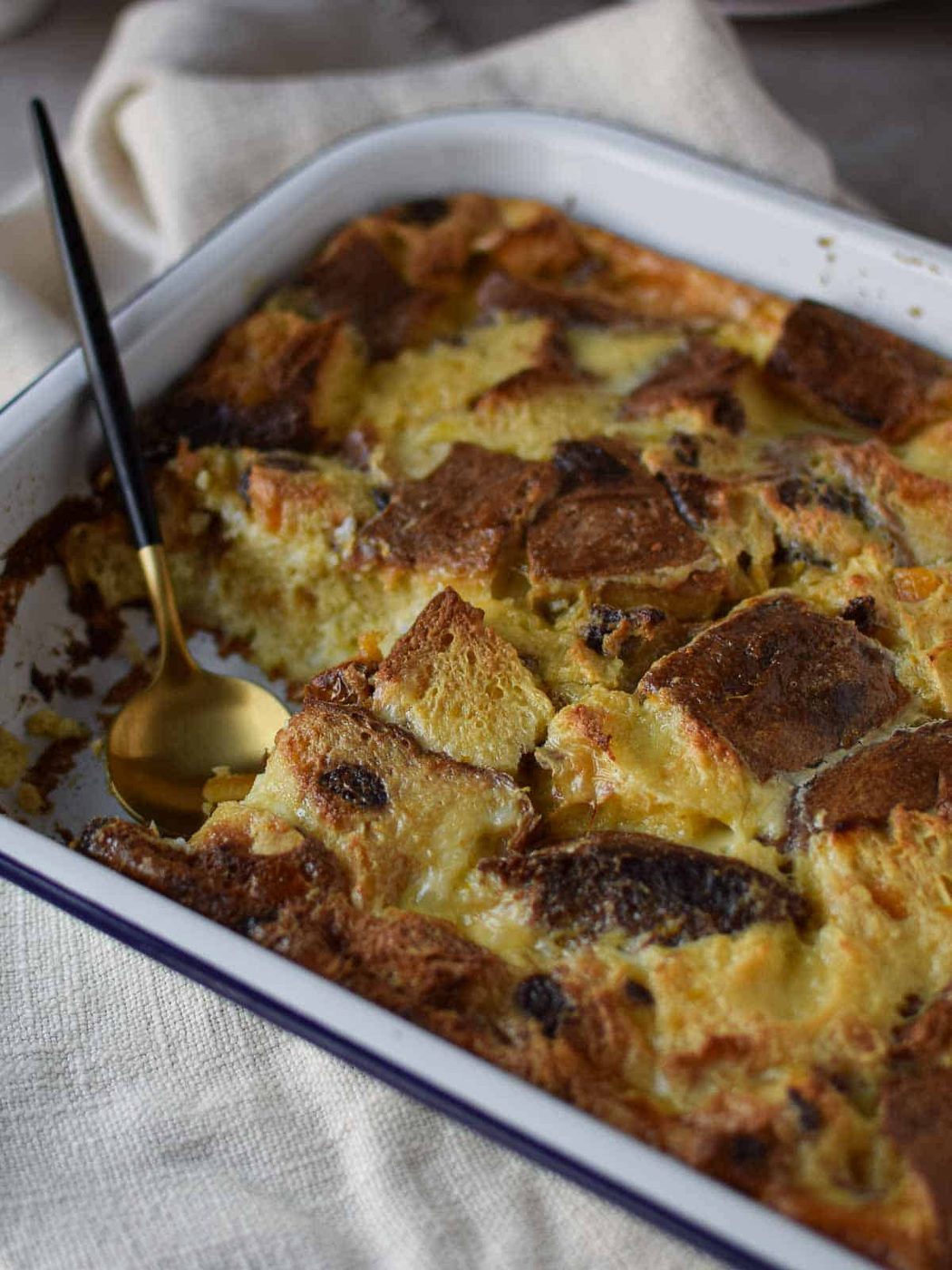 Panettone bread pudding in a large baking pan with a slice taken out.