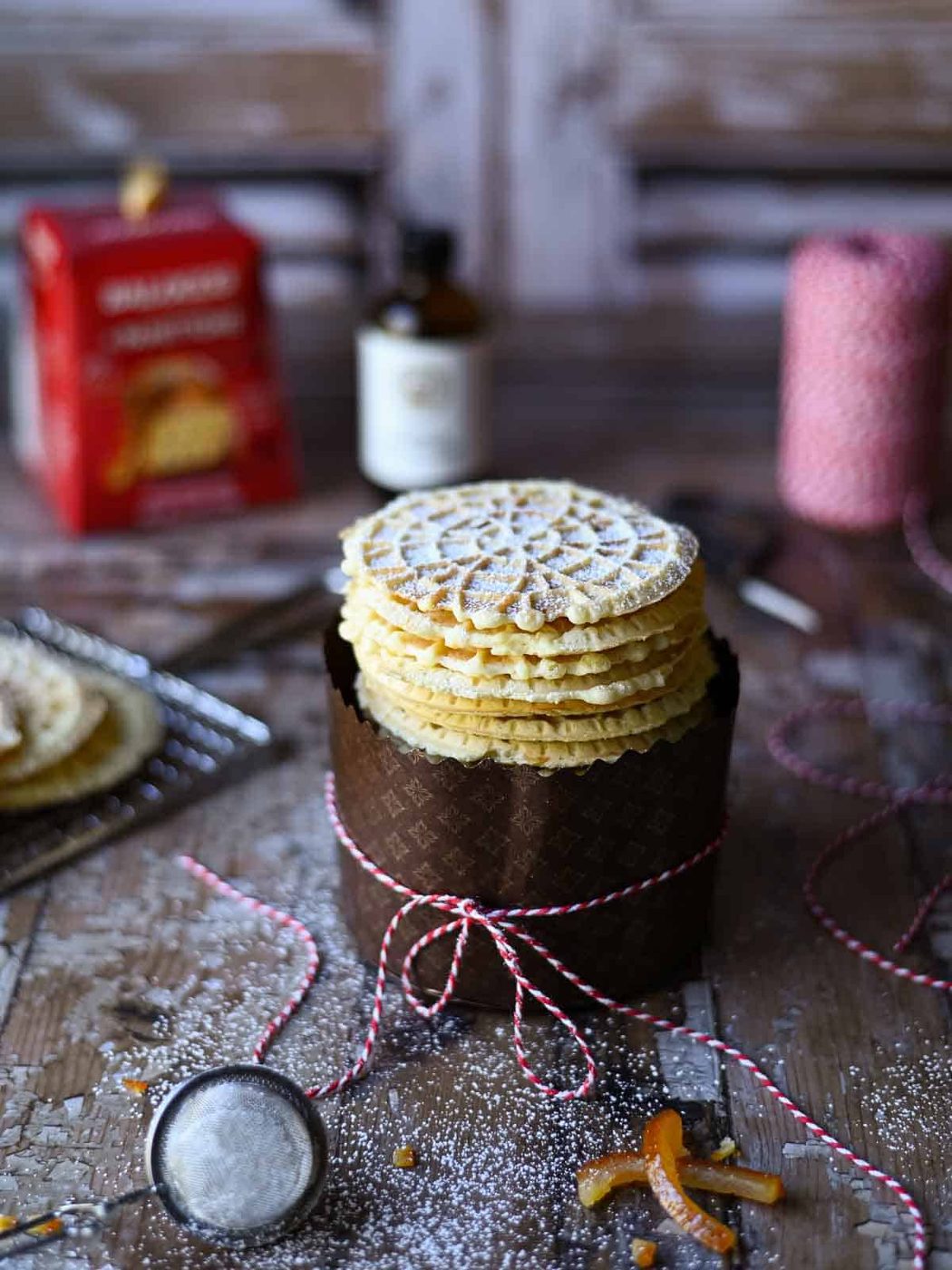 Angled view of panettone pizzelle in a wrapper with bakers string around it.