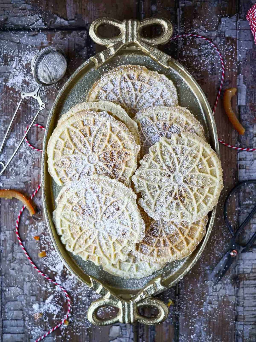 Overhead of pizzelle cookies on an oval plate with bows.