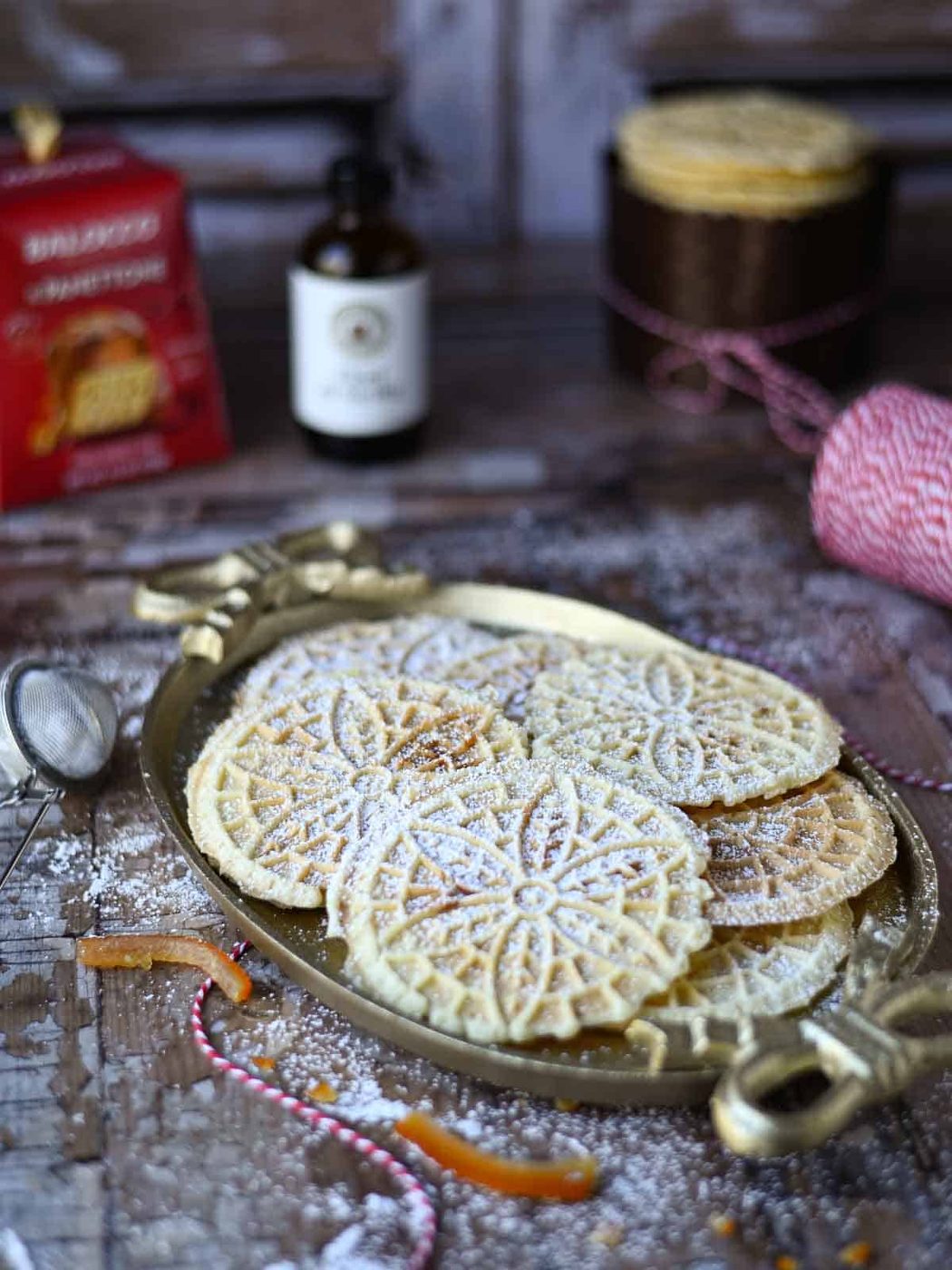 Pizzelle on an oval platter on a wood surface.