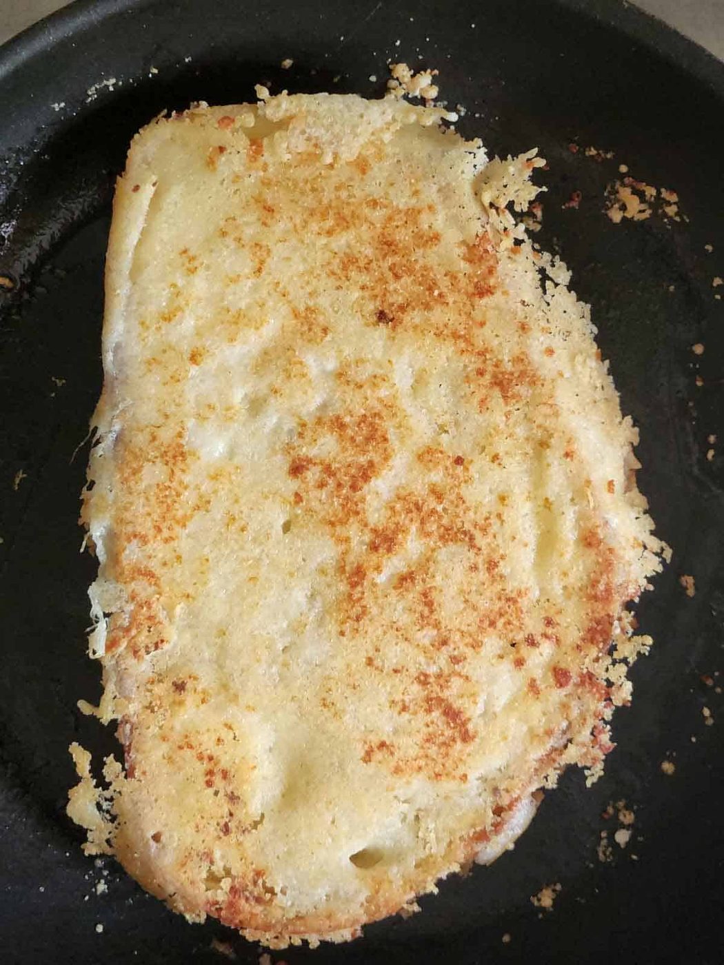 Parmesan crusted toast in a black skillet.