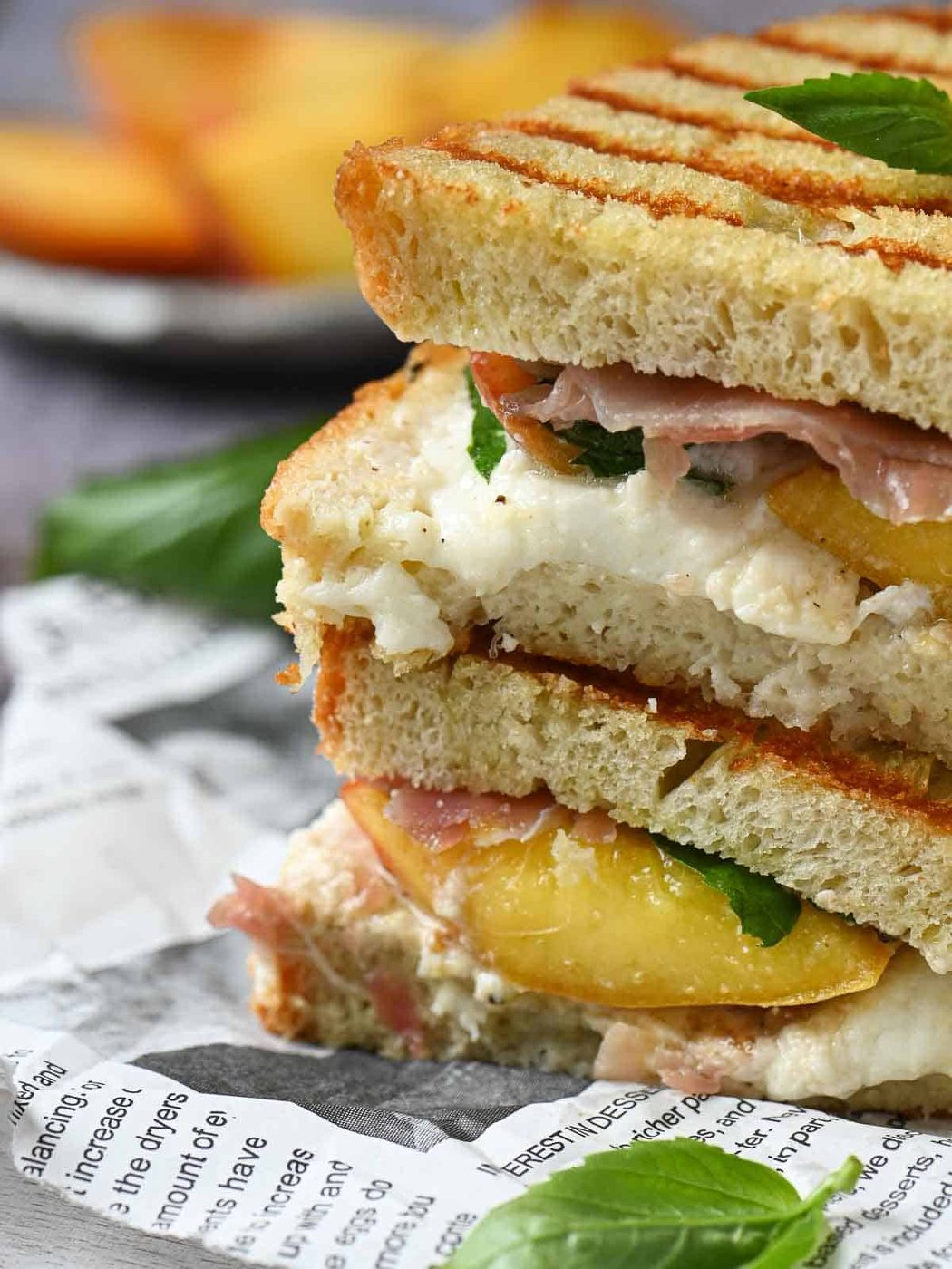 Close-up of peach panini with basil and burrata.
