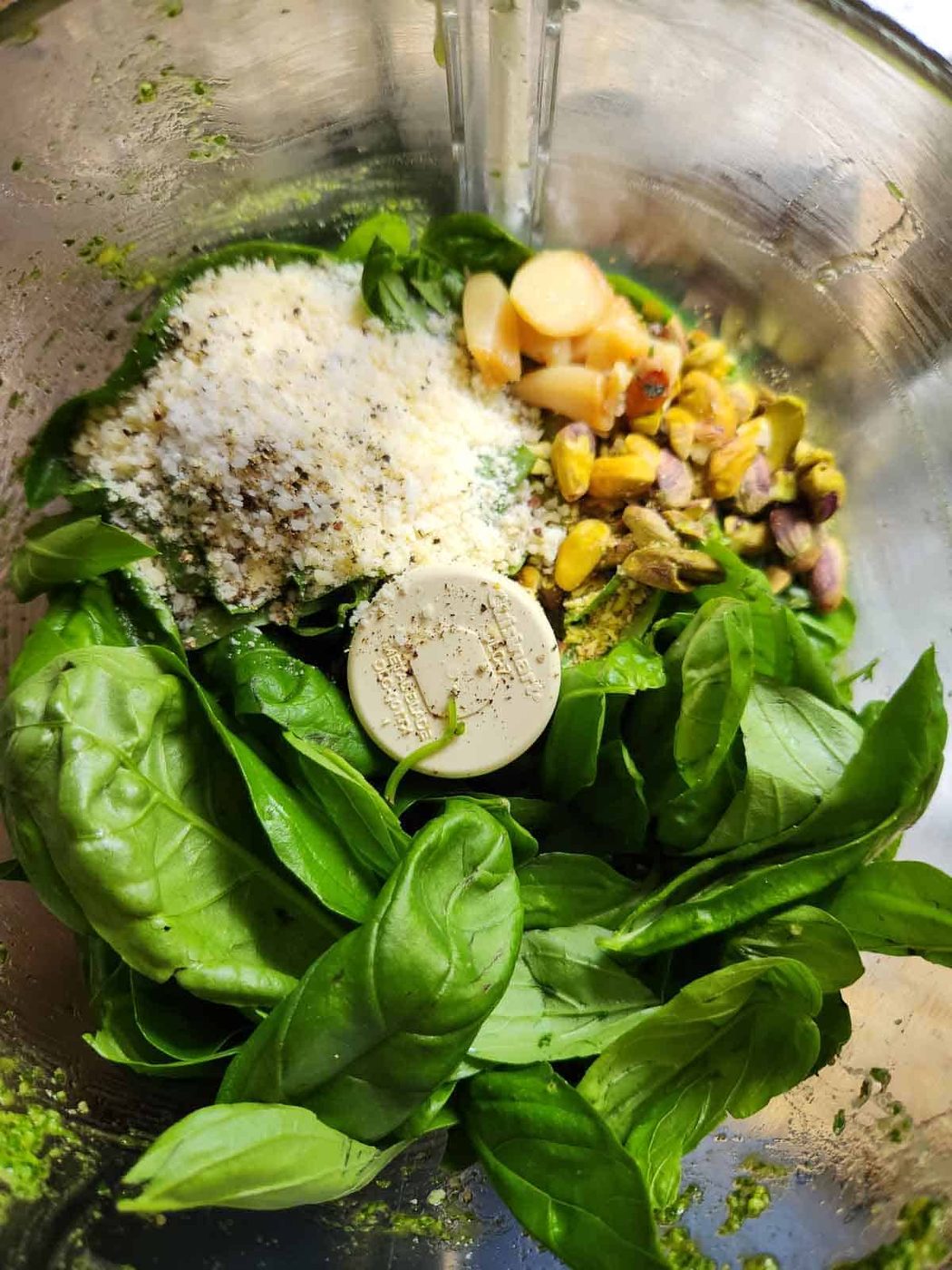 Ingredients for roasted garlic pesto in a food processor.