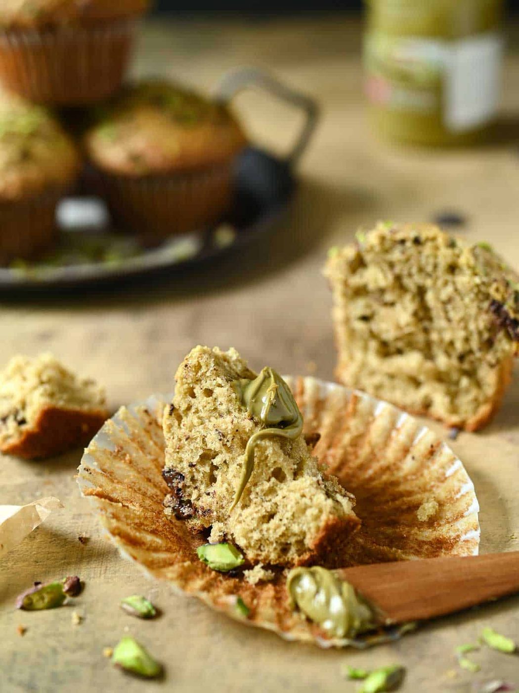A pistachio muffin cut in half with pistachio cream on it.