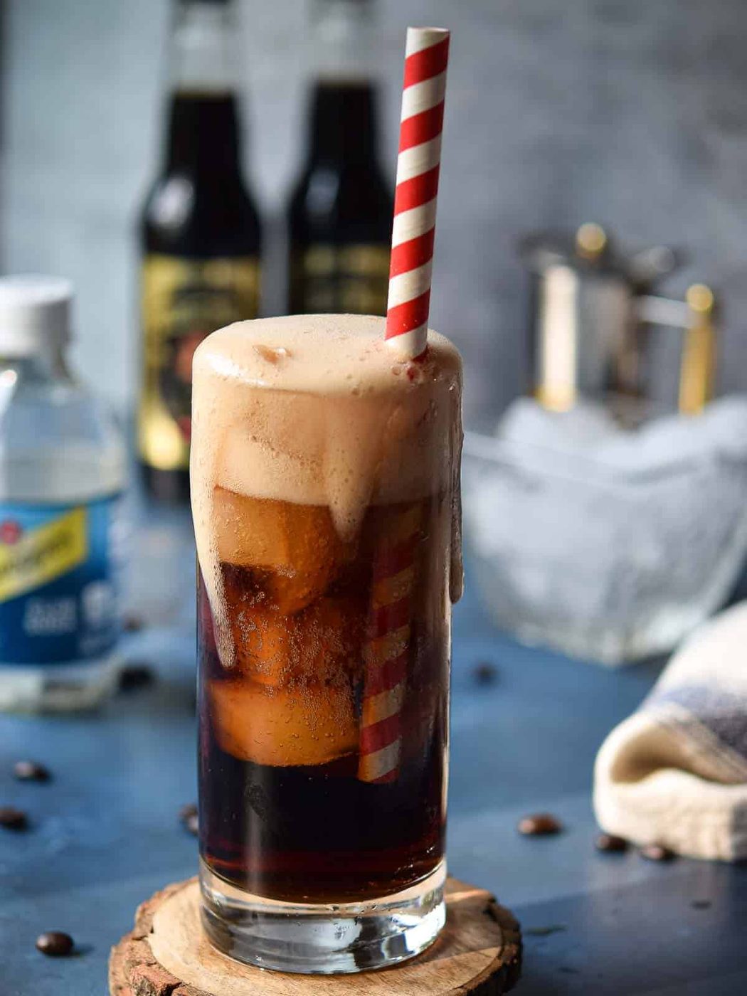 Espresso soda in a glass just poured with foam dripping down.
