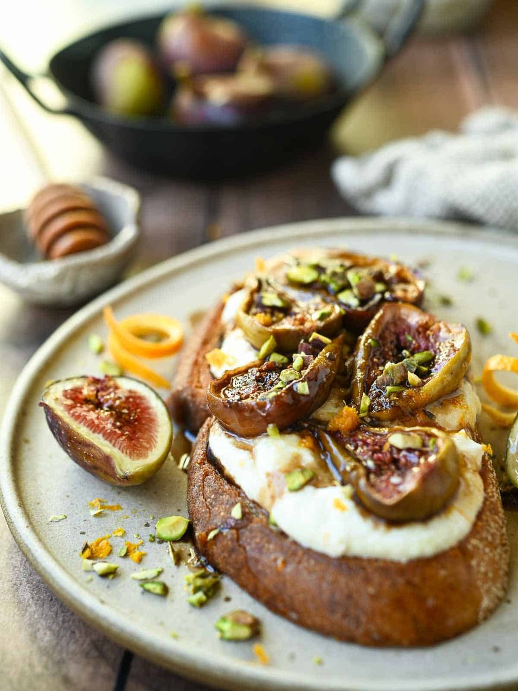 Eye-level view of balsamic fig toast on a brown plate.