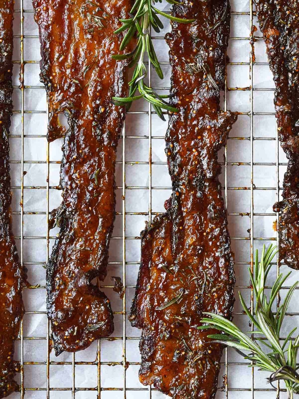Oven-baked fig jam candied bacon with fresh rosemary.