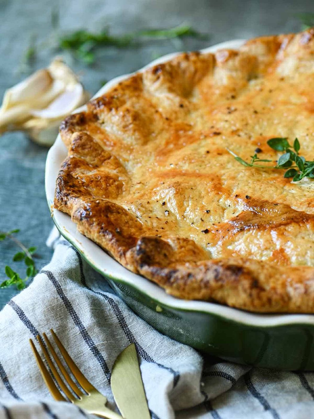 Close-up of chicken pie put showing the crust with herbs next to it.