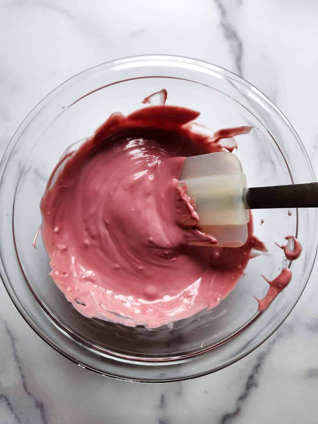 Melted ruby chocolate in a clear bowl.